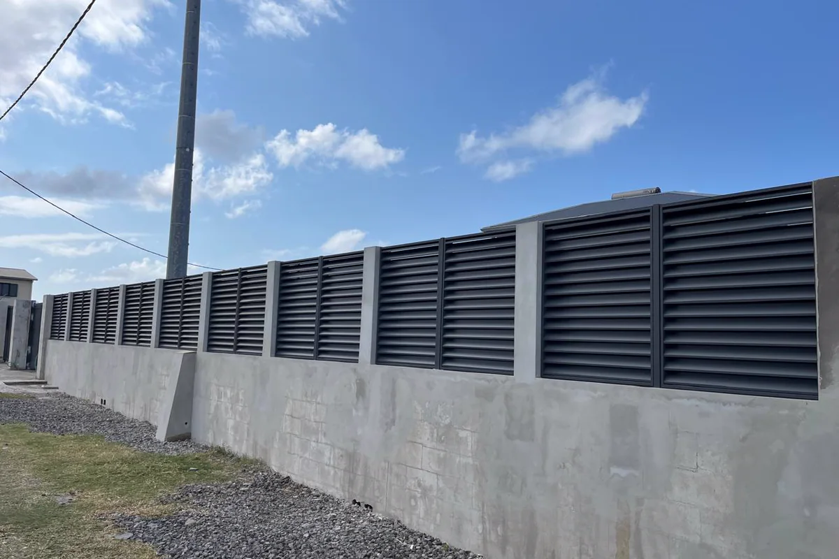 Clôture aluminium à lames anthracite sur un muret béton
