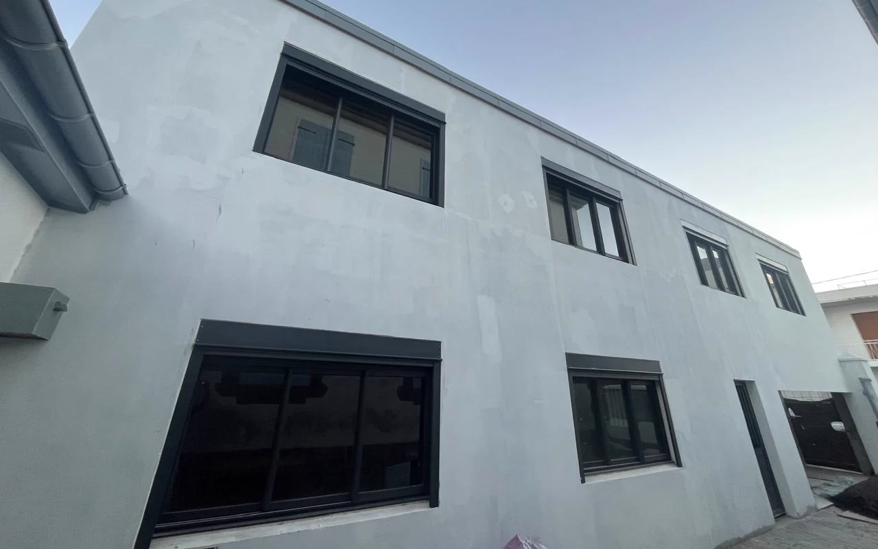 Fenêtres et baies coulissantes aluminium anthracite sur une façade neuve