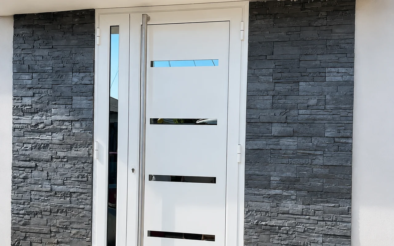 Porte d'entrée aluminium blanche vitrée avec imposte latérale, encadrement en parement de pierre