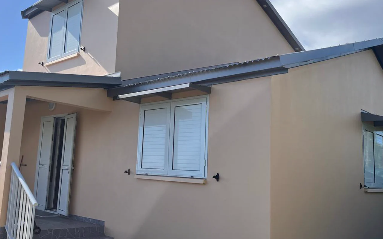 Volets battants à lames aluminium blancs sur une fenêtre